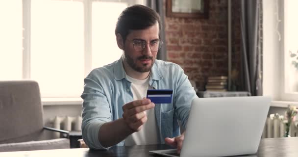 Man håller kreditkort betala räkningar på nätet använda laptop — Stockvideo