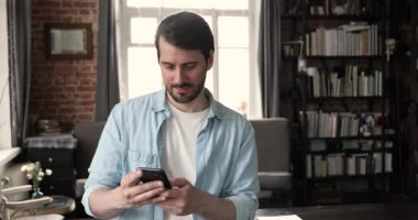Gülümseyen işadamı akıllı telefonda cep telefonu uygulaması kullanıyor