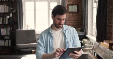 Tablet üzerinde çalışan işadamı gülümseyen bir iş başvurusu kullanıyor.