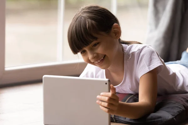 Happy gen Z kid girl watching movie on tablet computer — Stock Photo, Image