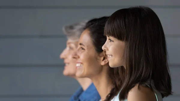 Счастливая девушка, стоящая в очереди с мамой и бабушкой, — стоковое фото