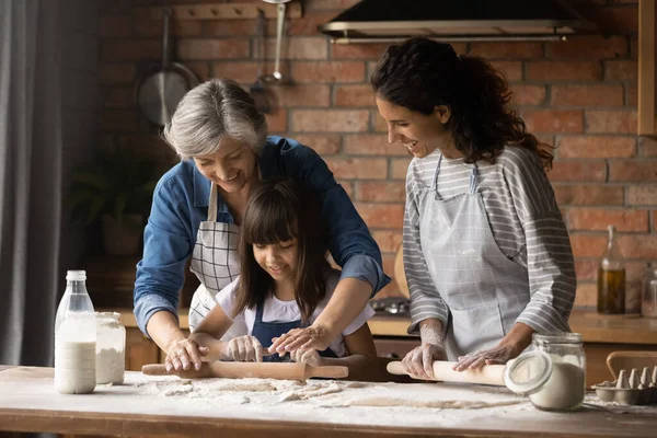 Happy Hispanic mom and grandma teaching girl to bake — Stock Photo, Image