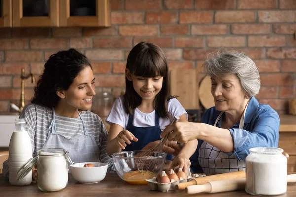 Mutlu Latin anne ve büyükanne kızlara yemek yapmayı öğretiyor. — Stok fotoğraf