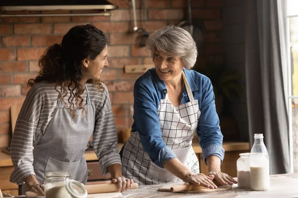 Happy Latin grown daughter and senior mother cooking at home — Stock Photo, Image