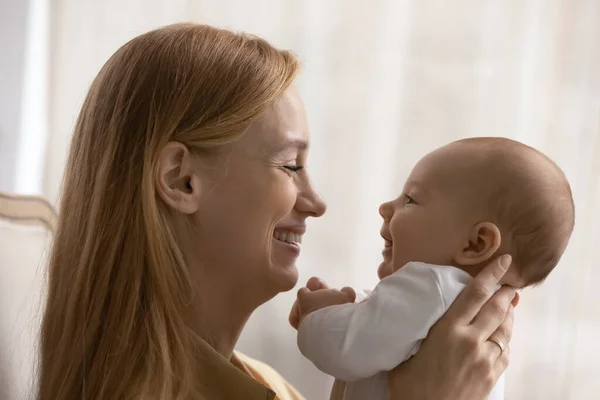 Profiel uitzicht glimlachen liefdevolle jonge moeder spelen met baby — Stockfoto