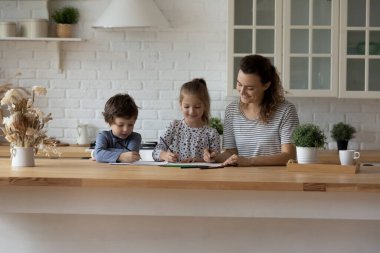 Mutlu küçük çocuklar anneleriyle kağıt albüm çiziyor..