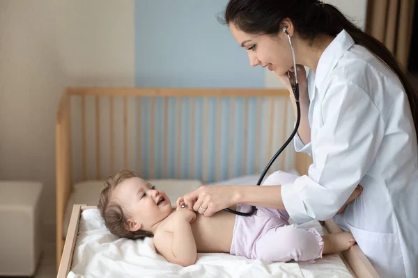 Lachende vrouwelijke arts kinderarts met behulp van stethoscoop, controleren van kleine meisje longen — Stockfoto