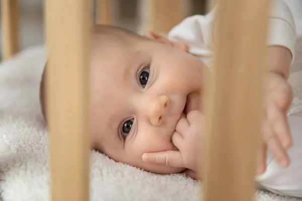Cabeza retrato lindo bebé acostado en cuna de madera —  Fotos de Stock