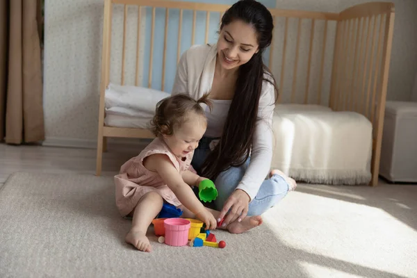 Lycklig ung mor och liten dotter leker med leksaker tillsammans — Stockfoto