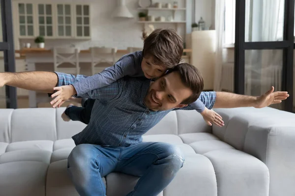 Счастливый молодой заботливый отец играет с маленьким сыном. — стоковое фото
