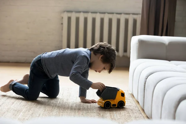 Feliz niño lindo niño jugando coche de juguete en casa. —  Fotos de Stock