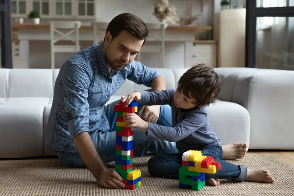 Amare felice affettuoso giovane padre giocare giocattoli con il piccolo figlio. — Foto Stock
