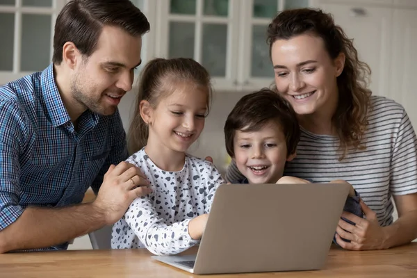 Glada små barn som använder dator appar med par föräldrar. — Stockfoto