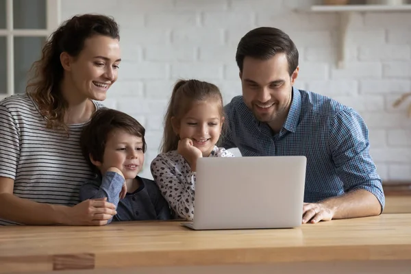 小さな子供とコンピュータを使用して幸せな思いやりのある若い親. — ストック写真