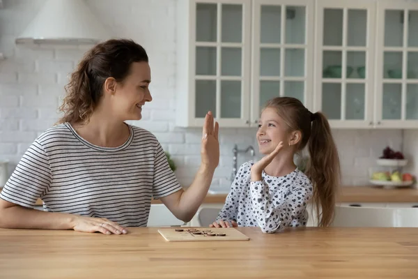 Happy young mum giving high five to laughing small daughter. — Stock Photo, Image