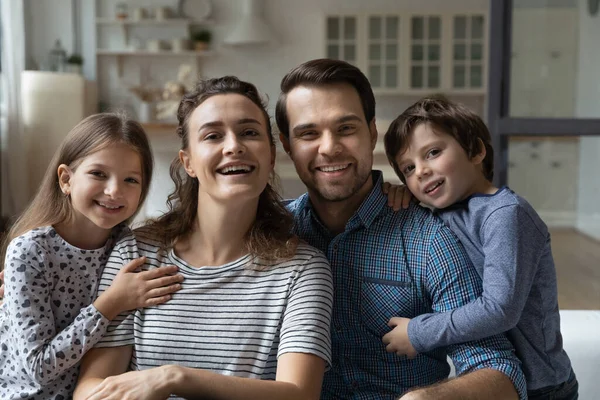 Porträt lächelnder Eltern und kleiner Kinder, die zu Hause posieren. — Stockfoto
