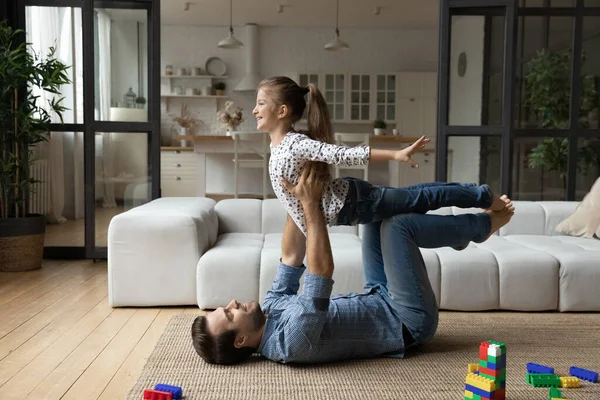 Felice giovane padre forte sollevamento carino piccolo bambino figlia. — Foto Stock