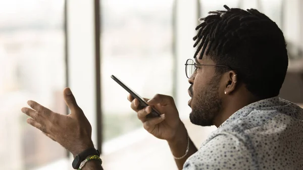 Joven hombre multirracial grabando mensaje de audio en el teléfono celular. —  Fotos de Stock