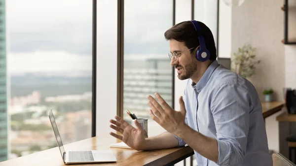 Happy young man in headphones holding video call conversation. — Stock Photo, Image