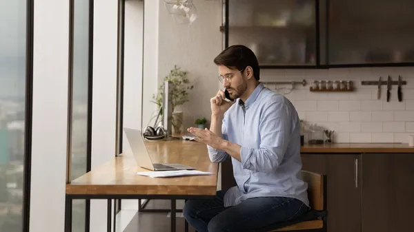 Concentrado joven empresario multitarea en casa oficina. — Foto de Stock