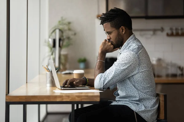 Tänksam ung blandad ras affärsman som arbetar med dator. — Stockfoto