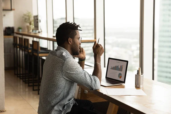 Focado jovem empresário africano multitarefa em home office. — Fotografia de Stock