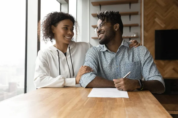 Счастливая молодая африканская пара обсуждает подписание контракта. — стоковое фото
