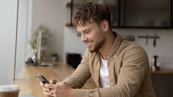 Felice bello giovane uomo utilizzando applicazioni per cellulari. — Foto Stock