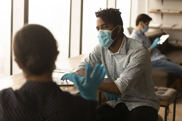 Two young mixed race employees communicating, preventing spreading virus. — Stock Photo, Image