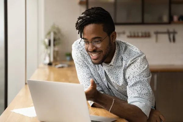 Glad ung afrikansk etnicitet affärsman läser e-post med goda nyheter. — Stockfoto