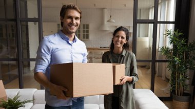 Ev sahiplerinin aileleri ellerinde büyük karton kutular ve eşyalar tutuyor.