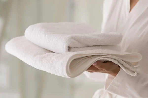 Female holds stack of fresh white towels, close up view — Stock Photo, Image