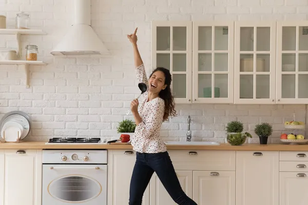 Femme distraite de la cuisine, tient louche chantant dansant dans la cuisine — Photo