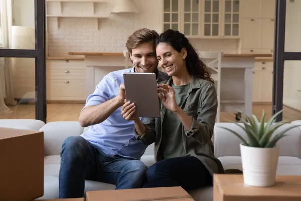 Uso en pareja tableta digital comprar muebles en línea para la nueva casa — Foto de Stock