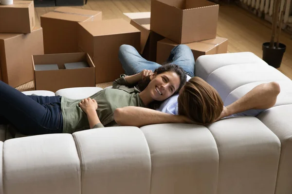 Happy couple resting on sofa at relocation day — Stock Photo, Image