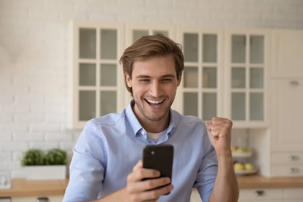 Man håller mobiltelefon ta emot sms med goda nyheter känns överlycklig — Stockfoto