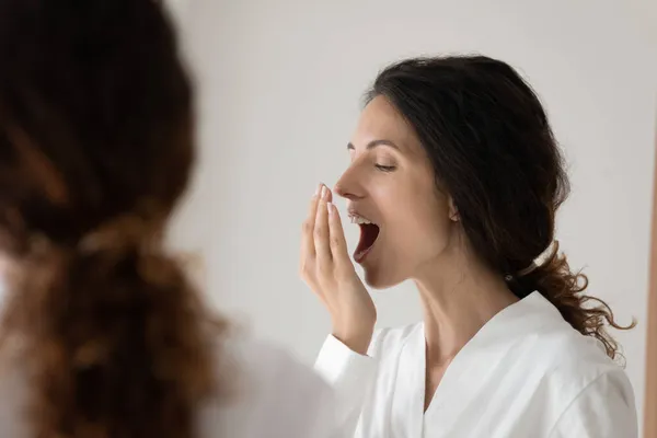 Mujer cubrir la boca con la palma comprobación de la frescura aliento —  Fotos de Stock