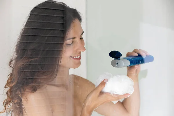 Woman squeezing douche gel on washcloth before taking a shower — Stock Photo, Image