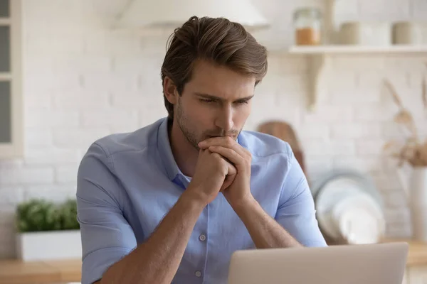 Man inför utmaningen tänker över lösning stirrar på laptop — Stockfoto