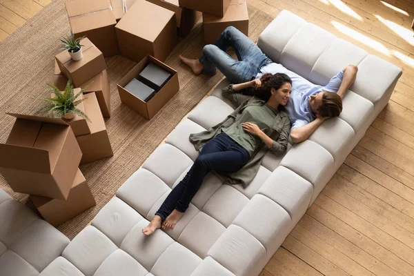 Overhead view couple relaxing on sofa near cardboard boxes — Stock Photo, Image