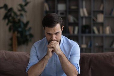 Kafası karışmış mutsuz genç adam olumsuz düşüncelere daldı..