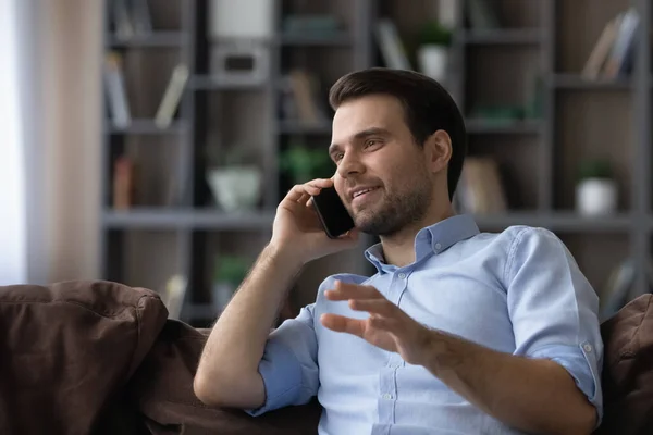 Sonriente joven guapo hombre celebración agradable llamada telefónica conversación. — Foto de Stock