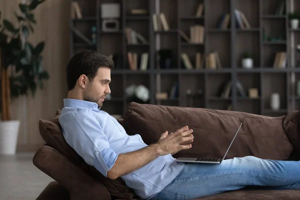 Relajado joven sosteniendo conversación de video llamada. — Foto de Stock