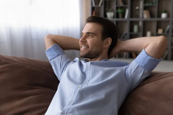 Relaxed young man lying on comfortable sofa. — Stock Photo, Image