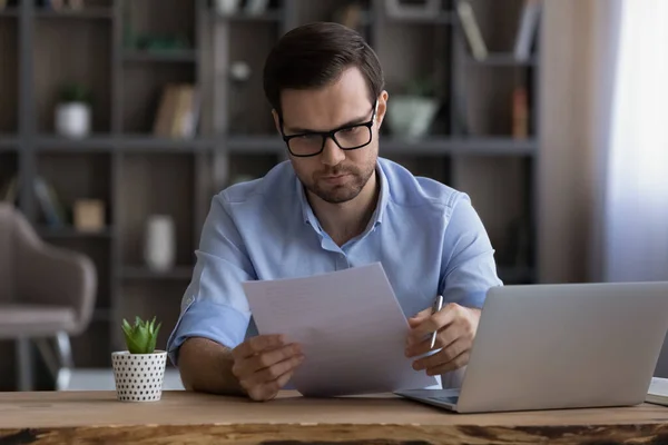 Uppmärksam skicklig ung affärsman läsa papper dokument. — Stockfoto