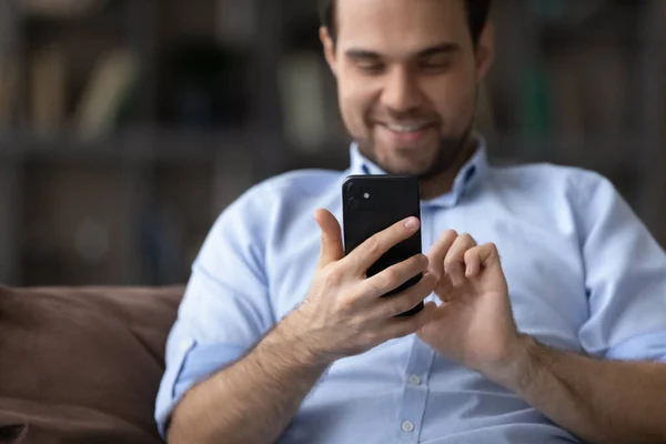 Jovem alegre usando aplicativos de celular em casa. — Fotografia de Stock