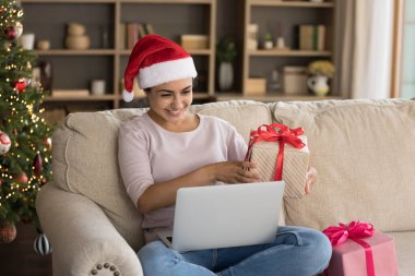 Mutlu Hintli kadın, elinde paketlenmiş bir hediyeyle görüntülü arama yapıyor..