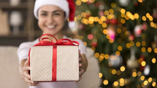 Focus sur enveloppé cadeau de Noël dans les mains de la femme indienne. — Photo