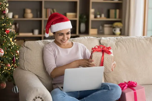 Mutlu Hintli kadın, elinde paketlenmiş bir hediyeyle görüntülü arama yapıyor..