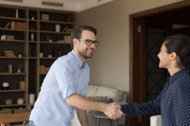 Genç ve mutlu iş adamı, kadın partnerle el sıkışıyor..